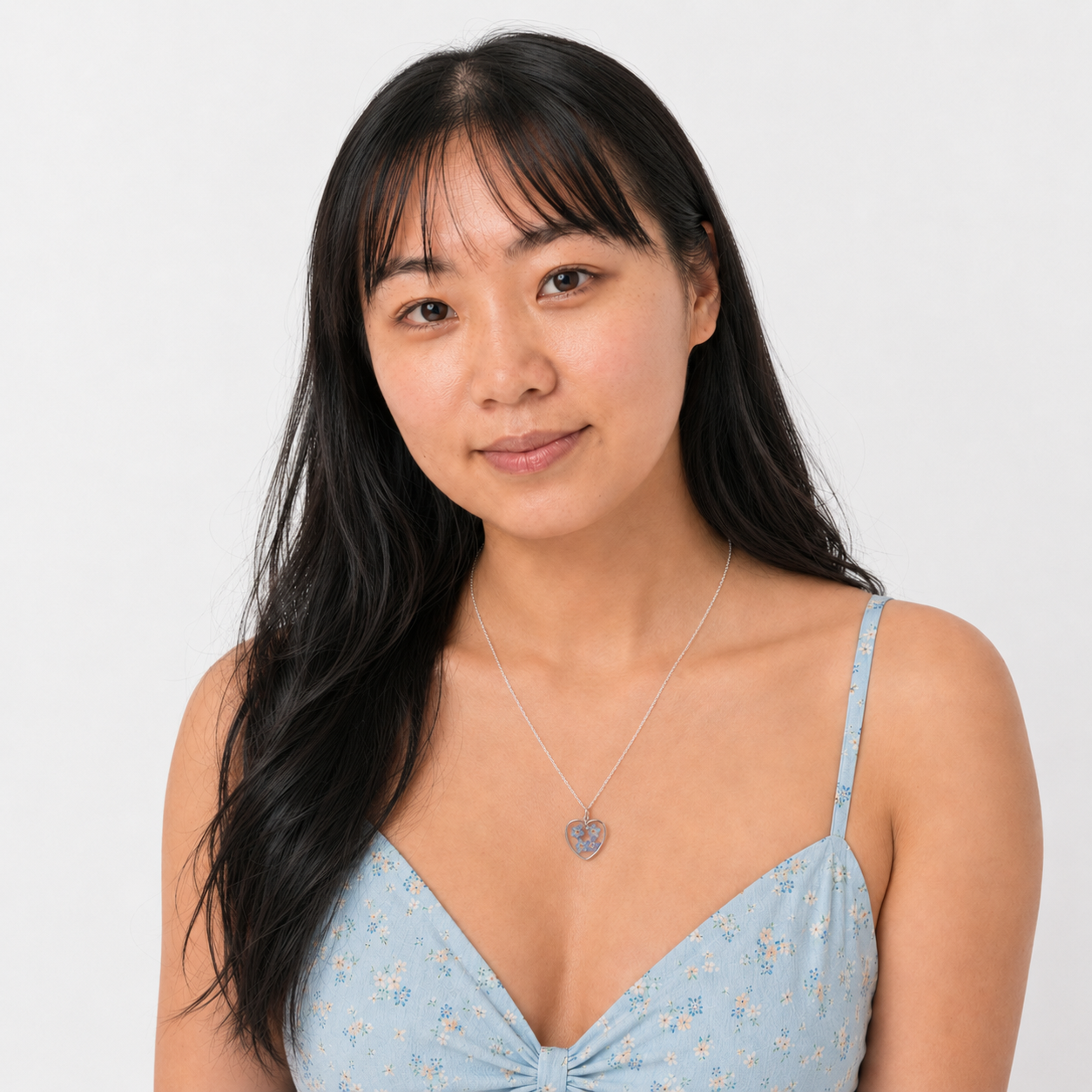 Model wearing a silver Forget-Me-Not heart necklace