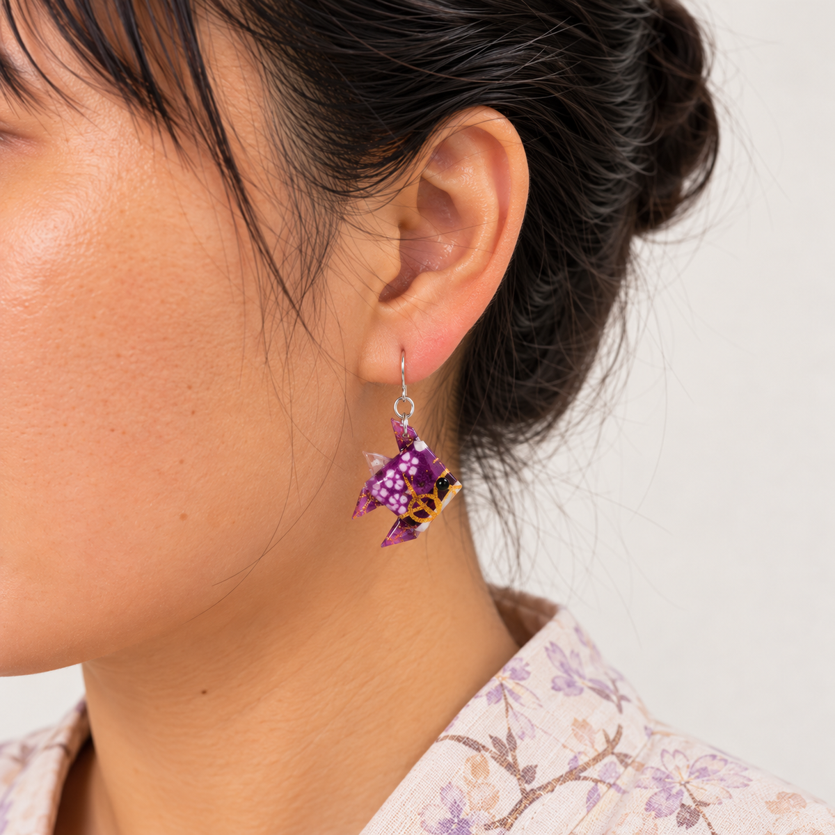 Purple origami fish earring worn with sterling silver fixings